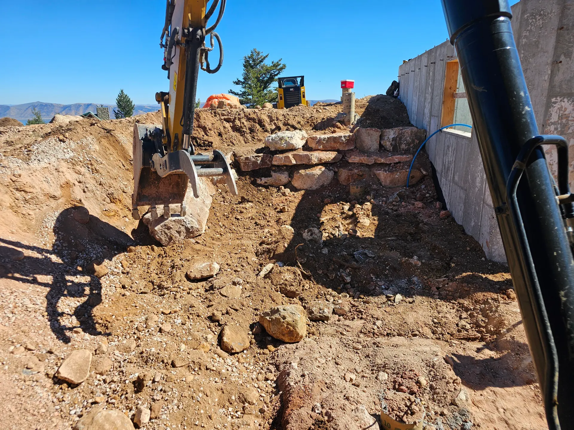 Heavy excavation machinery cutting a mountain pad